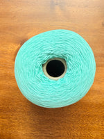 Load image into Gallery viewer, 100 Cotton Tape Cone Yarn in a soft mint green color, showcasing its smooth texture and cone shape.