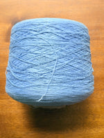 Load image into Gallery viewer, 100 linen Cone Yarn in light blue color, showcasing the texture and structure of the yarn cone.