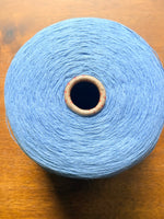 Load image into Gallery viewer, 100 linen Cone Yarn in light blue color, showcasing the texture and structure of the yarn cone.