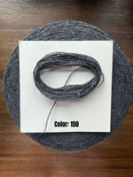Load image into Gallery viewer, UPW 100 Extrafine Merino Wool cone in color 150 displaying a soft gray yarn texture on a wooden surface.