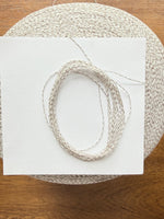 Load image into Gallery viewer, Ishikawa Safari Washi Blend Cone Yarn showcasing a soft white color in a cone shape on a wooden surface.