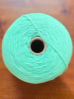 Load image into Gallery viewer, 100 Cotton Tape Cone Yarn in mint green color on wooden table, showcasing soft texture and ribbon-like structure.