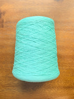 Load image into Gallery viewer, 100 Cotton Tape Cone Yarn in a soft mint green color, showcasing its smooth texture and cone shape.