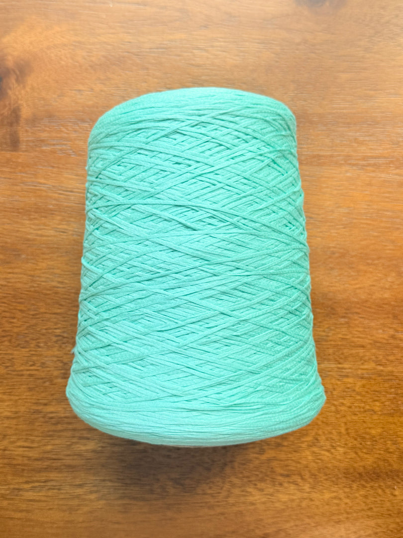 100 Cotton Tape Cone Yarn in a soft mint green color, showcasing its smooth texture and cone shape.