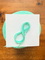 Load image into Gallery viewer, 100 Cotton Tape Cone Yarn in a soft mint green color, showcasing its smooth texture and cone shape.