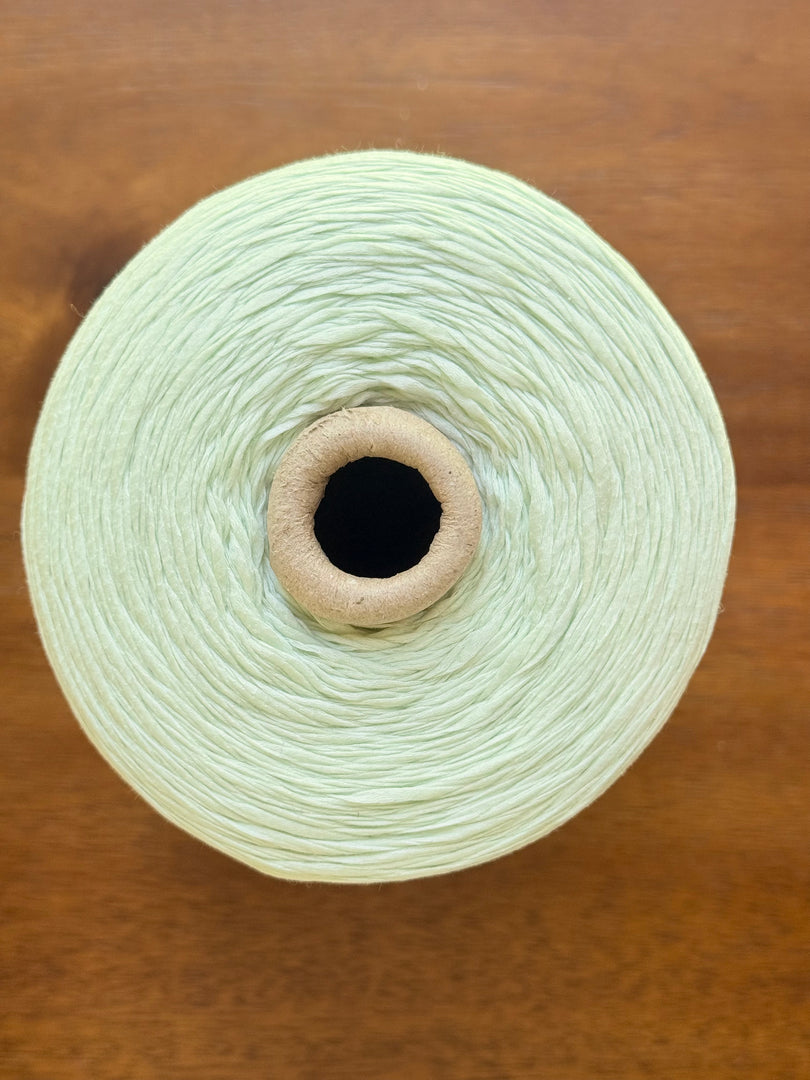 100 Cotton Tape Cone Yarn in a soft mint green color, showcasing its smooth texture and cone shape.