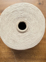 Load image into Gallery viewer, 100 Linen Cone Yarn displayed on a wooden surface, showcasing its natural texture and lightweight design.