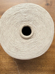 100 Linen Cone Yarn displayed on a wooden surface, showcasing its natural texture and lightweight design.