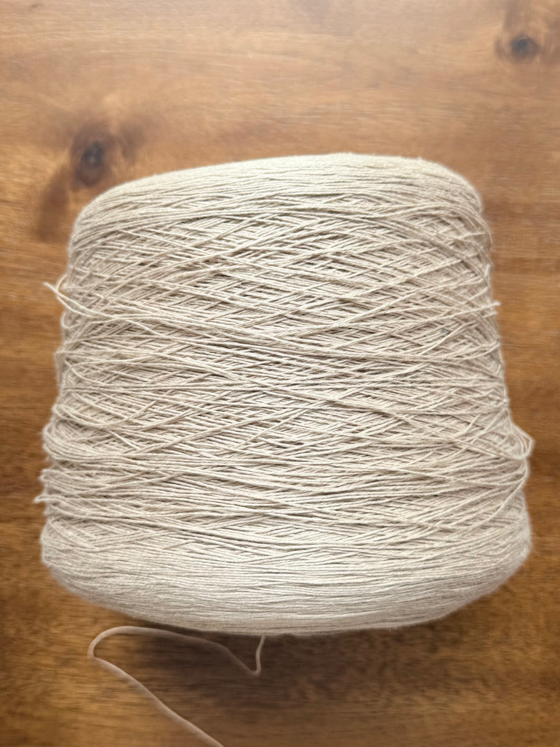 100 Linen Cone Yarn displayed on a wooden surface, showcasing its natural texture and lightweight design.