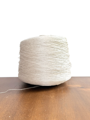 100 Linen Cone Yarn displayed on a wooden surface, showcasing its natural texture and lightweight design.