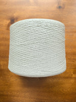 Load image into Gallery viewer, Maruyasu Techne 51 Paper 49 Modal Cone Yarn on a wooden table, showcasing its light color and smooth texture.